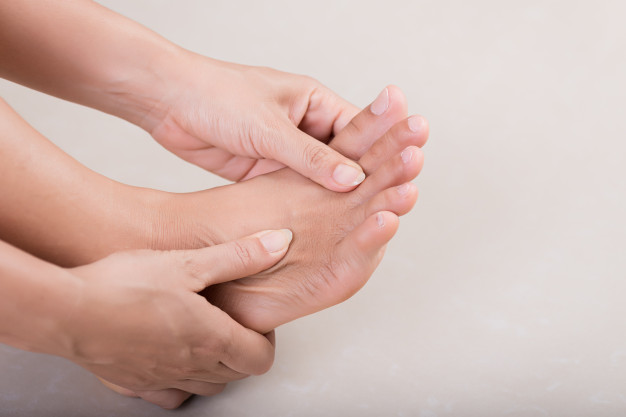 Lady holding her foot due to metatarsal fracture