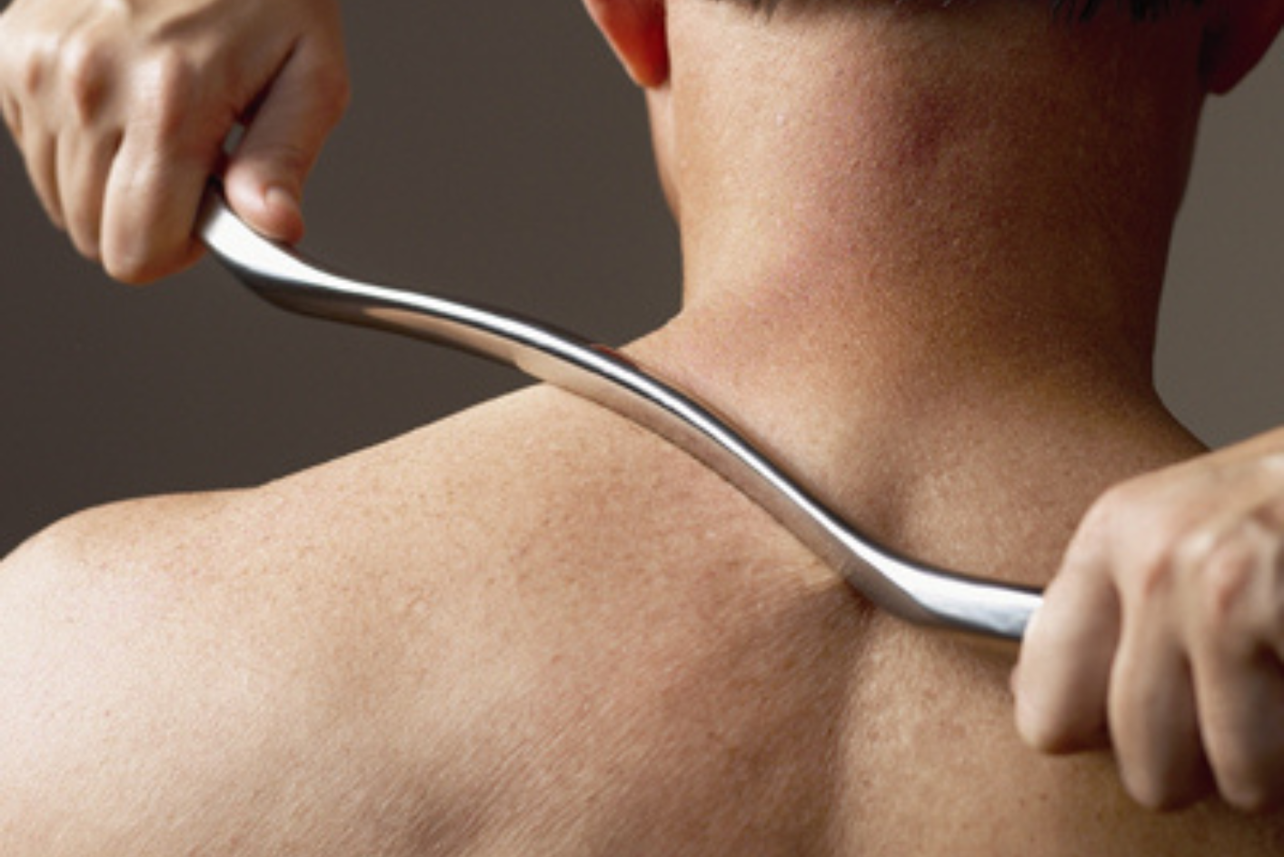 A man receiving a treatment using IASTM techniques