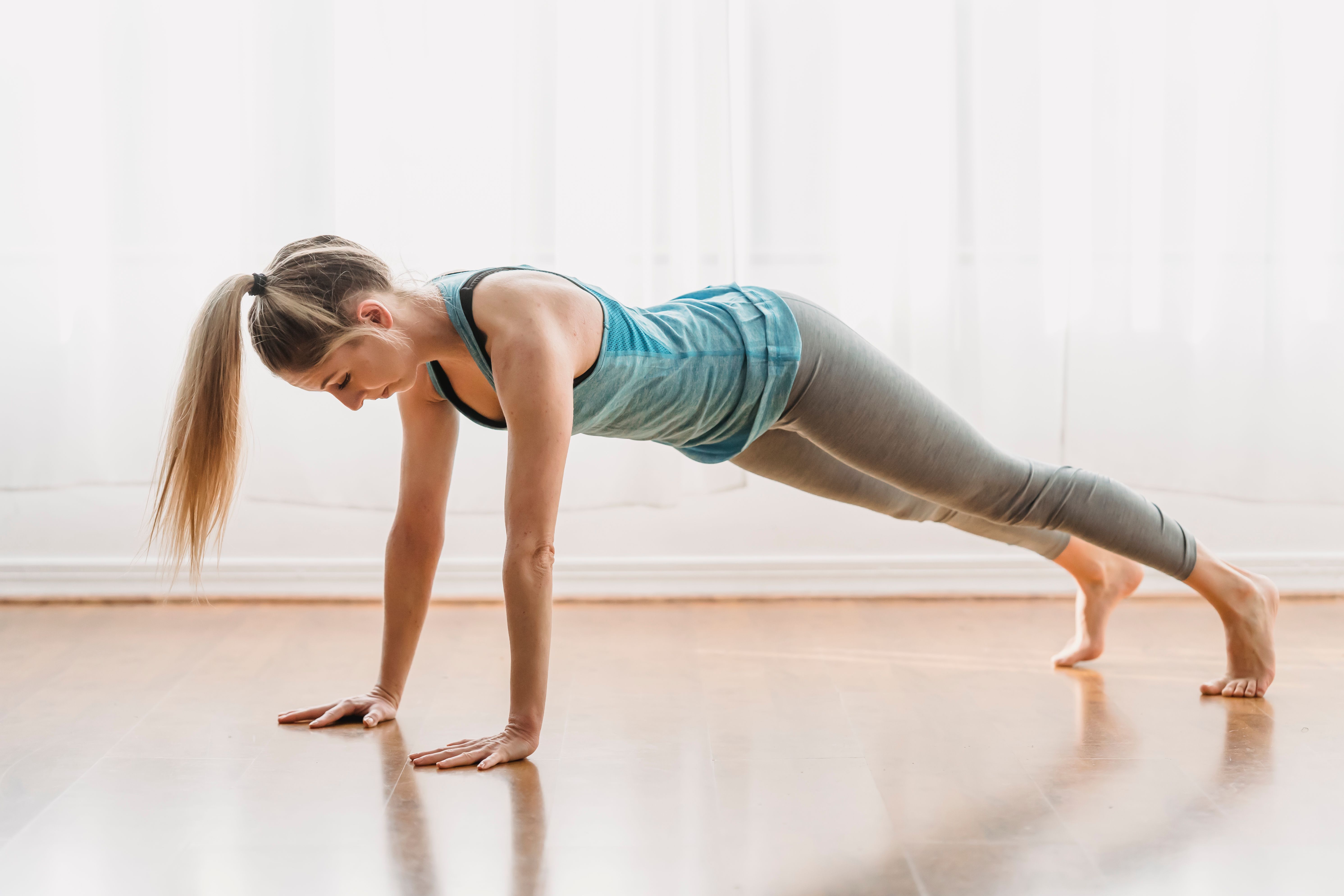 Woman exercising at home demonstrating the importance of including strength training